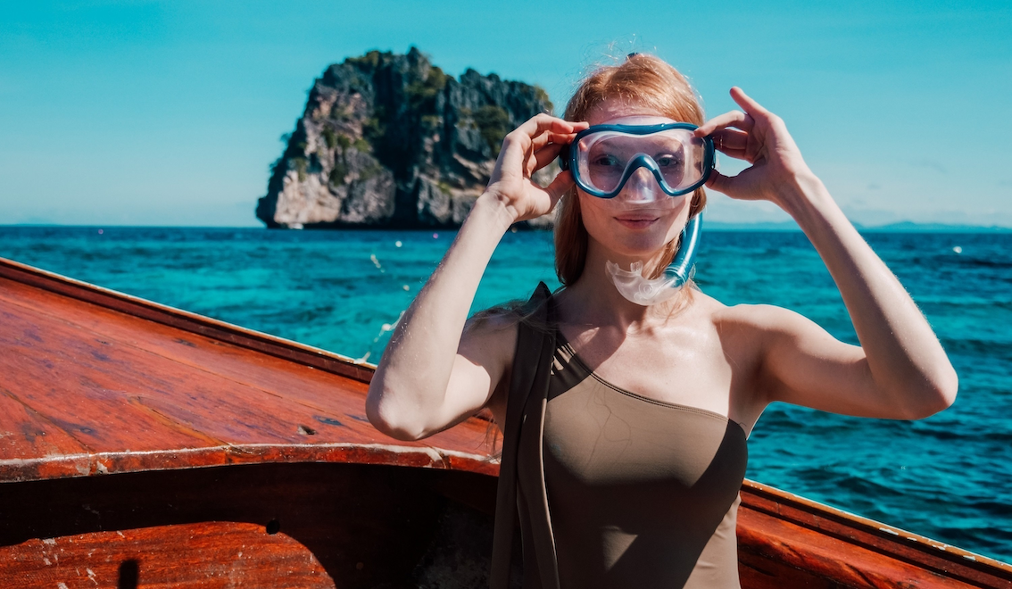 A women with goggles getting ready to snorkel